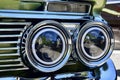 Close Up of a Classic Green IMPALA's Front Two Headlights with the extra lens