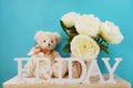 Friday word decorative letters with whit peony flower and teddy bear on wooden background Royalty Free Stock Photo