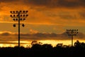 Friday night lights during the time of COVID: Playing field floodlights against clouds and trees at sunset #3