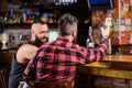 Friday relaxation in bar. Friends relaxing in pub. Hipster brutal bearded man spend leisure with friend at bar counter Royalty Free Stock Photo