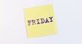 Friday word inscription on yellow paper sticker on white wall