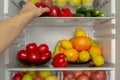 Fridge is filled with vegetables, fruits. Hand takes food from the refrigerator Royalty Free Stock Photo