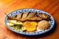 Fried anchovy served with patacon, coconut rice and vegetable salad Royalty Free Stock Photo
