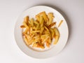 Fried appetizing potatoes on a white plate
