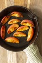 Fried apple, Pink Lady variety, in a cast iron frying pan. On a chopping board in a kitchen
