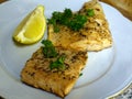 Fried arctic char trout fish fillets on white plate