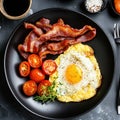 A fried bacon, eggs and roasted tomatoes breakfast garnished with herbs Royalty Free Stock Photo