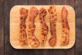 Fried bacon strips on the wooden board Royalty Free Stock Photo
