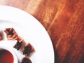 This is fried bacon in white plate served with chili sauce, above wooden table, soft tone