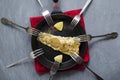 Fried baked mackerel trachurus with onions and dried herbs in an old frying pan in a towel, many different forks around