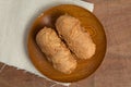 Fried bananas in wooden plate on white linen, Kluay Tod - Thai dessert Royalty Free Stock Photo