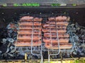 fried bbq sausages on the grill under hot coals top view Royalty Free Stock Photo