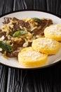 Fried beef liver with onion and sage, served with polenta close-up in a plate. vertical Royalty Free Stock Photo
