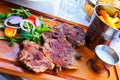 Fried beef steak with sauce, fried potatoes, arugula and tomatoes Royalty Free Stock Photo