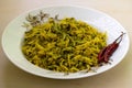 Fried bitter gourds and potatoes on a white plate with fried red chilies Royalty Free Stock Photo