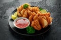 Fried Bloomin Onion with Chilli sauce and lime on black plate