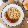 Fried botifarra sausage served with cooked white beans