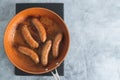 Fried bratwurst pork sausages on a frying pan close-up on the kitchen table, view from above, copy space Royalty Free Stock Photo