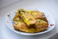 Fried bread in an egg with dill. Fried bread on a plate. Breakfast - bread and eggs.