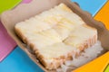 Toast topped with sweetened condensed milk in a paper dish on a wooden table. Royalty Free Stock Photo