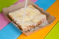 Toast topped with sweetened condensed milk in a paper dish on a wooden table. Royalty Free Stock Photo