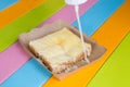 Toast topped with sweetened condensed milk in a paper dish on a wooden table. Royalty Free Stock Photo
