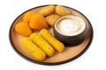 Fried breaded brie and camembert nuggets and mozzarella sticks on a rustic ceramic plate with white dip on white Royalty Free Stock Photo