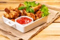 Fried breaded chicken wings with lettuce and with ketchup on a wooden background. fast food, close-up .Breaded chicken wings Royalty Free Stock Photo