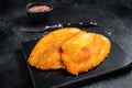 Fried breaded tilapia fillets on a marble board. Black background. Top view Royalty Free Stock Photo