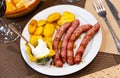 Fried butifarra sausages with fried potato slices are served on plate