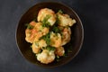 Fried cauliflower florets in batter on a black plate. Royalty Free Stock Photo