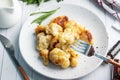 Fried cauliflower florets in batter on a white plate. White wooden background Royalty Free Stock Photo