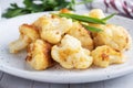Fried cauliflower florets in batter on a white plate. White wooden background. Royalty Free Stock Photo