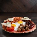 Fried champignons, fried eggs, juicy sausages, fried bacon, toast with butter and pickled beans in tomato sauce Royalty Free Stock Photo