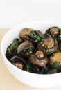 Fried champignons with garlic and parsley in a white bowl. The concept of vegetarian food. Royalty Free Stock Photo