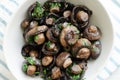 Fried champignons with garlic and parsley in a white bowl on the table. The concept of vegetarian food Royalty Free Stock Photo