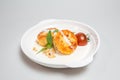 Fried cheese pancakes with sour cream and cherry tomatoes on white plate Royalty Free Stock Photo