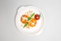 Fried cheese pancakes with sour cream and cherry tomatoes on white plate Royalty Free Stock Photo