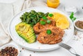 Fried chicken breast, avocado, beans and lemon on a light background. Royalty Free Stock Photo