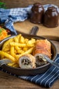 Fried chicken breast stuffed with mushrooms and cheese wrapped in ham served with fries and salad Royalty Free Stock Photo