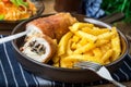 Fried chicken breast stuffed with mushrooms and cheese wrapped in ham served with fries and salad Royalty Free Stock Photo