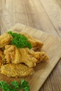 Fried Chicken,Crispy fried chicken wings on wooden plate,Parsley on top.