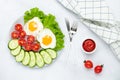 Fried chicken eggs with vegetables on a gray table. Breakfast concept. Top view. Flat lay composition. Food background in morning