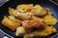 Fried chicken fillet in a black pan close-up. Many pieces of fried chicken, rolled in breadcrumbs. Homemade quick