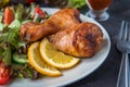Fried chicken legs and fresh salad on a dark background Royalty Free Stock Photo