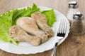 Fried chicken legs, leaves of lettuce in plate, salt, pepper