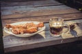 Fried chicken legs in a plate and a glass of beer on a wooden table/fried chicken legs with beer on a picnic on a sunny day