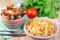 Fried chicken legs, potato and vegetables on wooden table Royalty Free Stock Photo