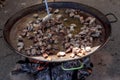 Fried chicken legs. Preparation of chicken paella.national Spanish dish of paella in a large skillet is cooked on an open fire, at Royalty Free Stock Photo