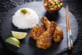 Fried chicken legs with teriyaki sauce sesame seeds rice on black stone Royalty Free Stock Photo